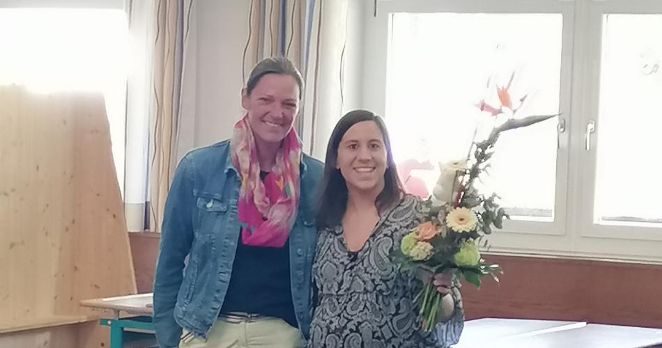 Direktorin übergibt Lehrerin zum Abschied einen Blumenstrauß