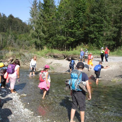 Kinder waten durch den Fluss