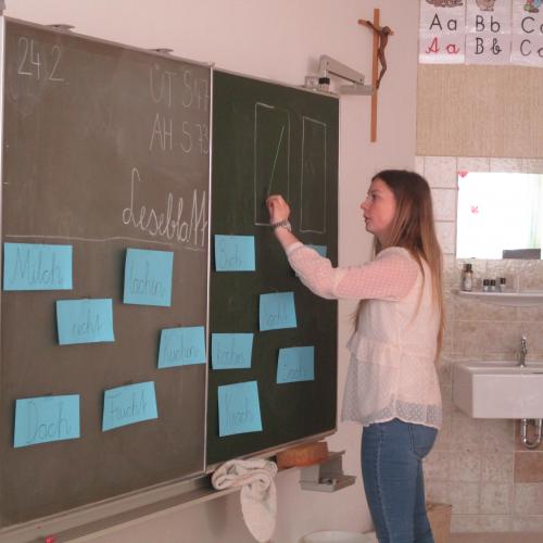 Lehrerin schreibt an Tafel