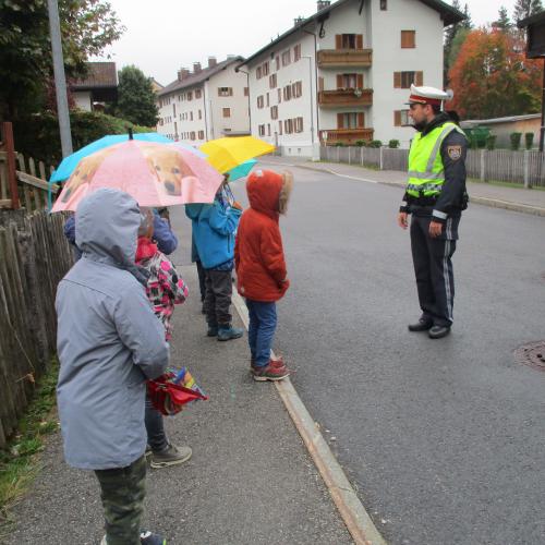 Kinder am Gehsteig mit Polizei