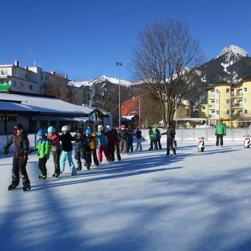 Kinder in einer Schlange am Eislaufplatz