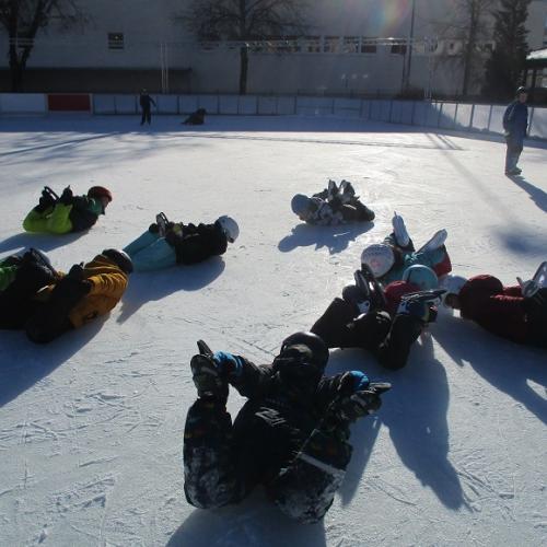 Kinder liegen auf dem Eis