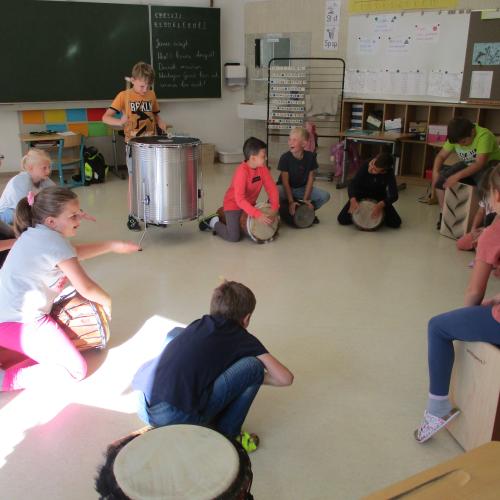 Kinder im Kreis beim Trommeln