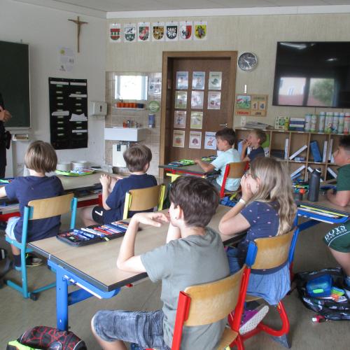 Kinder in der Klasse mit der Polizistin