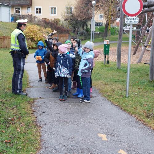 Kinder mit Polizist am Gehweg