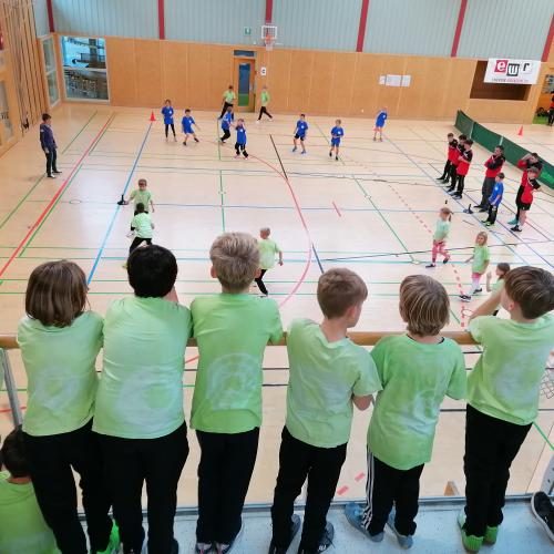 Kinder schauen von der Tribüne aus den Spielen zu