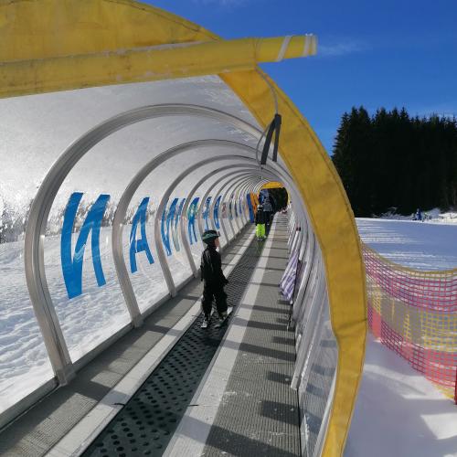 Kind auf Teppichlift in Tunnelröhre