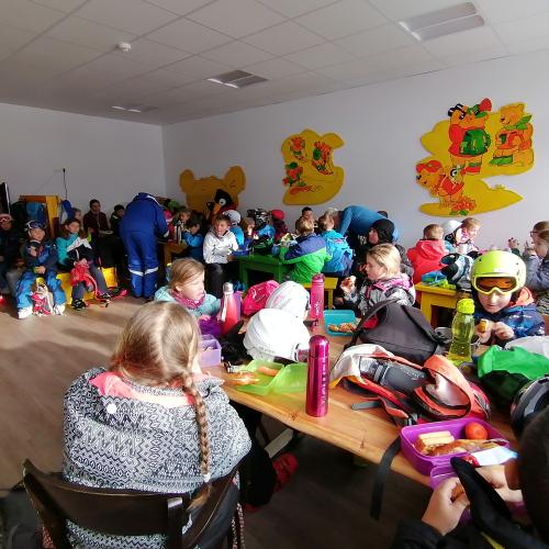 Kinder beim Jausnen im Pausenraum der Skischule