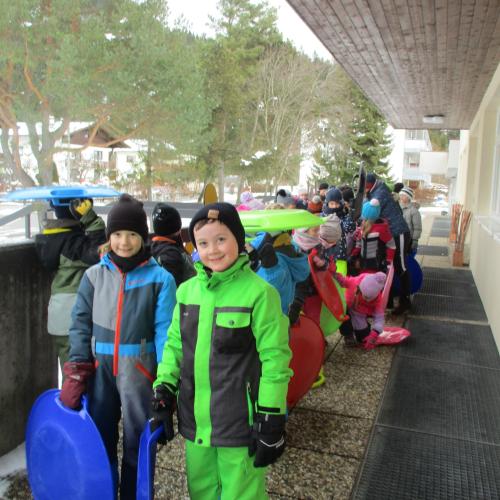 Kinder in einer 2er-Reihe vor der Schule