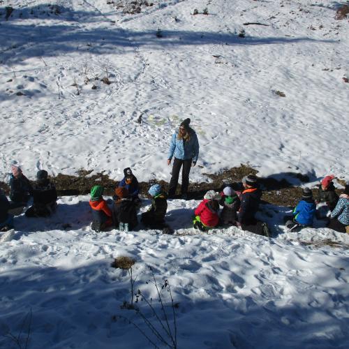 Kinder in Gruppen sitzend im Schnee