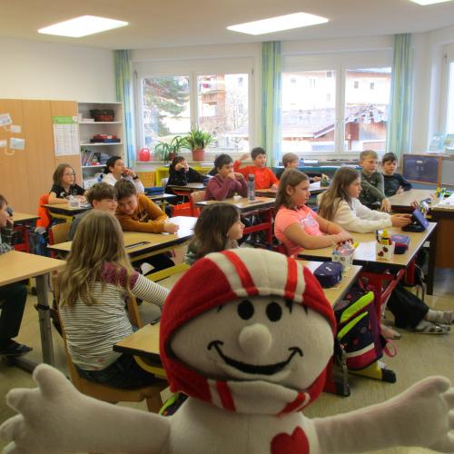 Kinder in der Klasse mit Handpuppe Helmi im Vordergrund