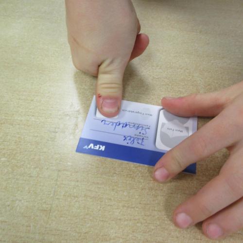 Kind macht einen Fingerabdruck vom Daumen