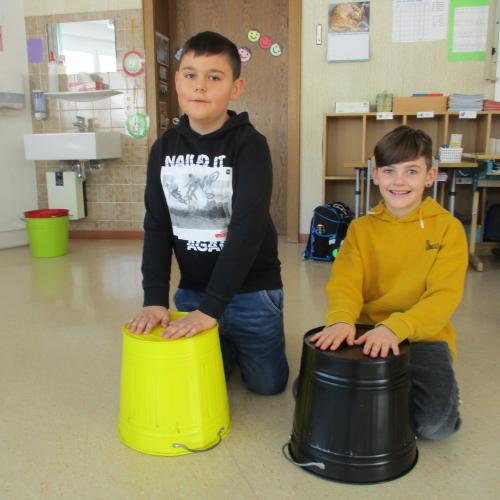 Kinder mit rhythmischen Instrumenten (Eimer)