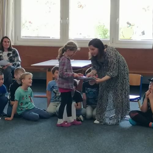 Kind aus 2. Klasse übergibt Lehrerin ein Abschiedsgeschenk