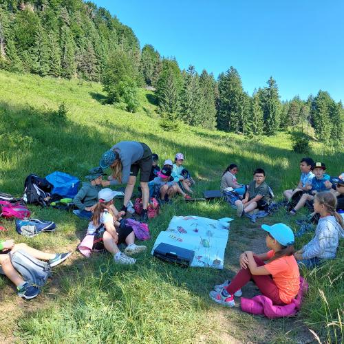 Kinder sitzen um Plakat herum