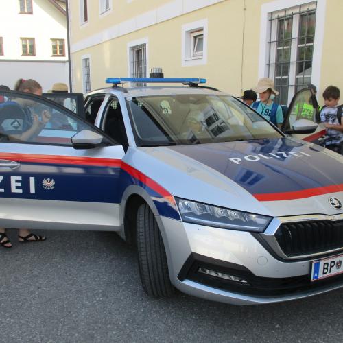 Kinder ums Polizeiauto