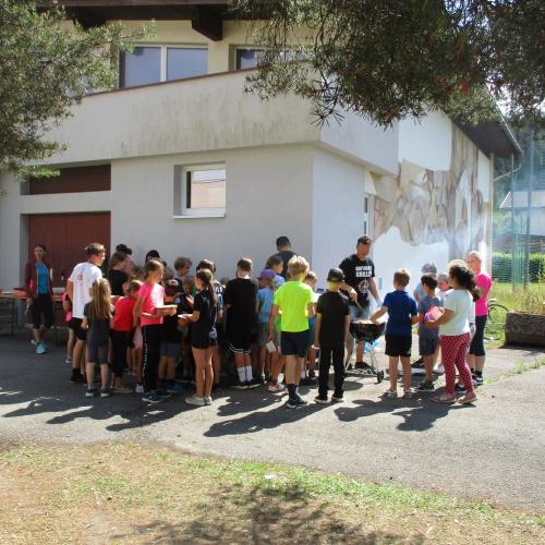 Kinder stehen am Grill an