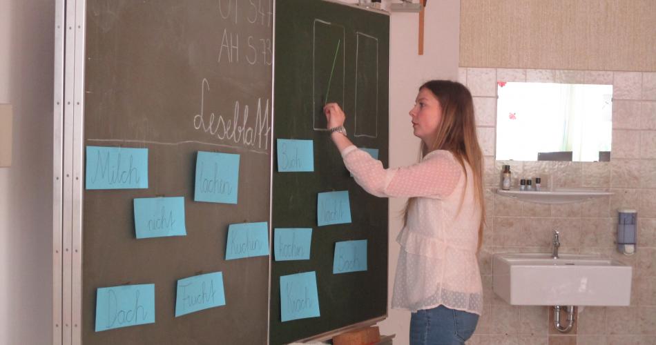 Lehrerin schreibt an Tafel